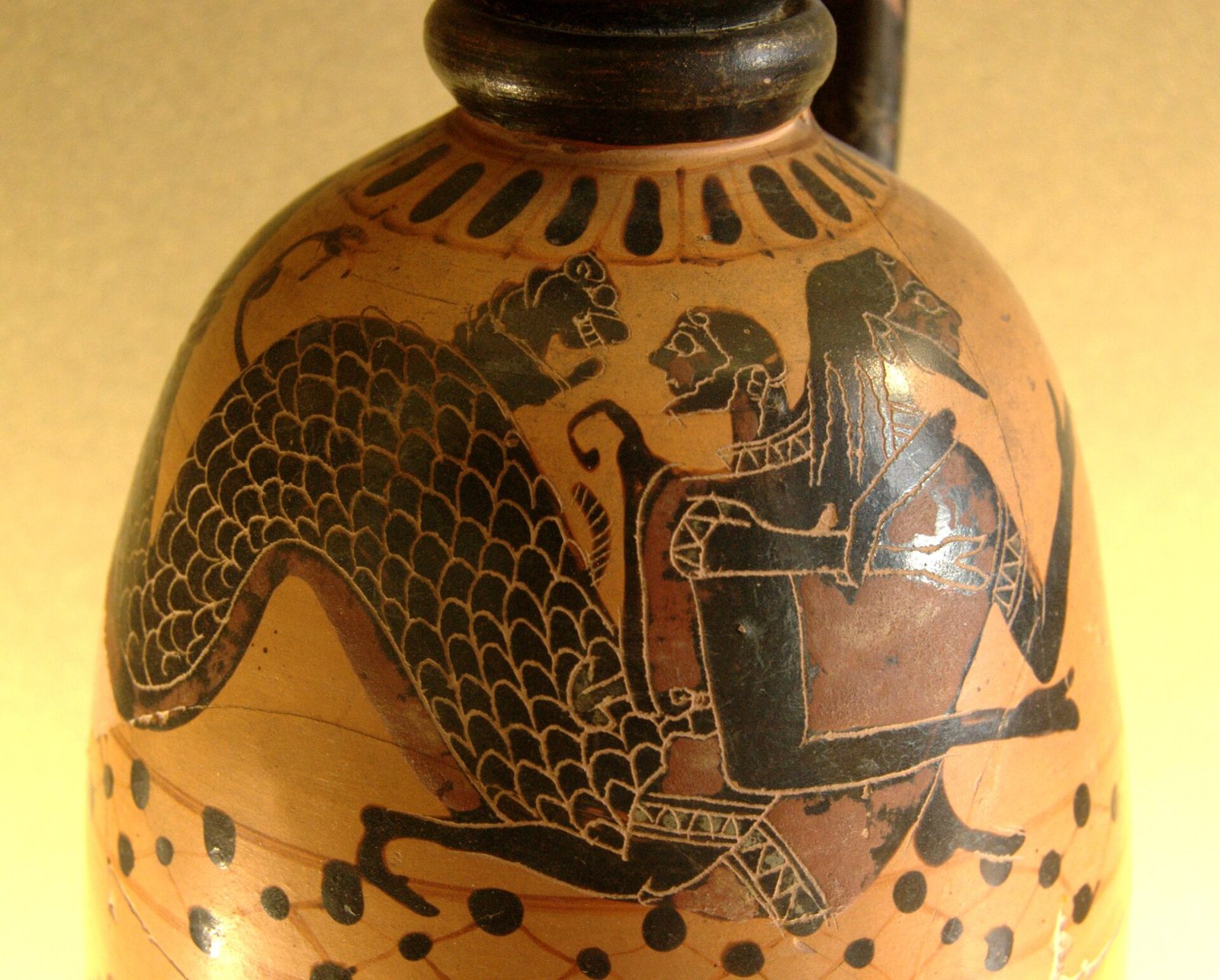 Black-figure painting on a small oil jar: Heracles grips Nereus, who has a fish's scaled tail and a lion springing from his back.